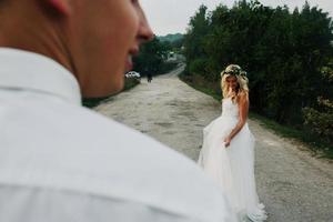 la mariée conduit le marié sur la route photo