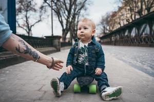 petit garçon drôle avec planche à roulettes dans la rue photo