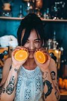 portrait femme adulte tenant orange tient une orange avec le sourire. photo