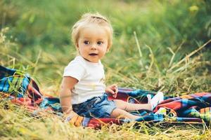 petite fille assise sur la pelouse photo