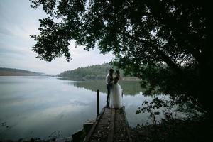 couple de mariage sur la vieille jetée en bois photo