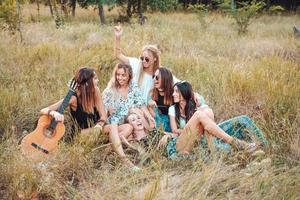 six filles dans la nature sont assises sur l'herbe. photo