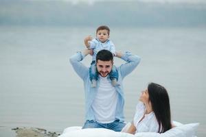 heureuse jeune famille se détendre ensemble sur le lac photo