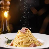 photo de produit spaghetti carbonara, fond noir bokeh photo premium