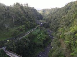 vue aérienne de la vallée avec petite rivière dans le mont pluyon merapi, indonésie. photo