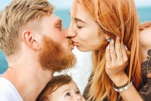 maman et papa s'embrassent. famille heureuse en vacances photo