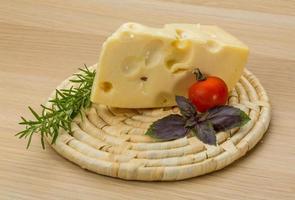 Fromage maasdam sur planche de bois et fond de bois photo