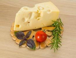 Fromage maasdam sur planche de bois et fond de bois photo