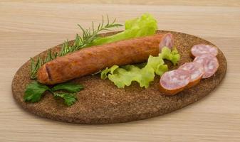 saucisse sur planche de bois et fond en bois photo