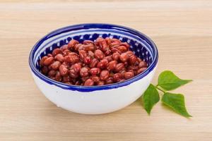 Haricots rouges dans un bol sur fond de bois photo