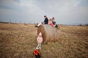 quatre enfants assis sur haycock au champ. photo