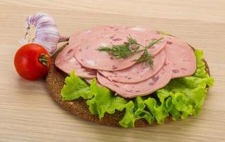 saucisse de boeuf sur planche de bois et fond de bois photo