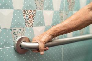 Une patiente asiatique âgée ou âgée utilise la sécurité de la poignée de la salle de bain des toilettes dans la salle d'hôpital de soins infirmiers, concept médical solide et sain. photo