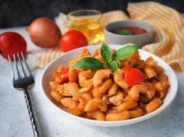 pâtes macaronis à la sauce tomate sur une table en bois blanc photo