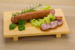 saucisse sur planche de bois et fond en bois photo