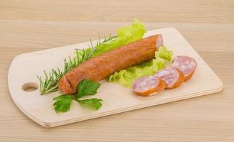 saucisse sur planche de bois et fond en bois photo