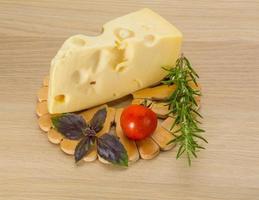 Fromage maasdam sur planche de bois et fond de bois photo