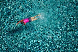 femme nager dans la piscine de l'hôtel. vue d'en-haut. photo