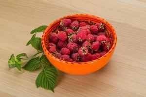 Framboise dans un bol sur fond de bois photo