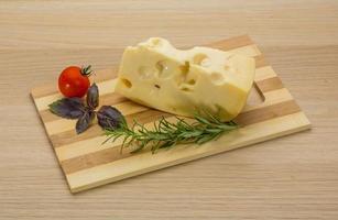 Fromage maasdam sur planche de bois et fond de bois photo