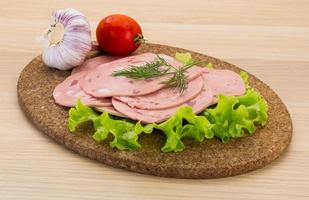 saucisse de boeuf sur planche de bois et fond de bois photo