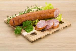 saucisse sur planche de bois et fond en bois photo