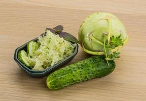Salade de chou-rave dans un bol sur fond de bois photo