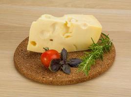 Fromage maasdam sur planche de bois et fond de bois photo