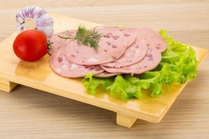 saucisse de boeuf sur planche de bois et fond de bois photo