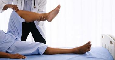 physiothérapeute faisant de la physiothérapie pour un patient adulte dans une chambre d'hôpital. photo