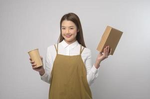 portrait de jeune femme asiatique portant un tablier sur fond blanc studio, cuisine et concept d'entrepreneur photo