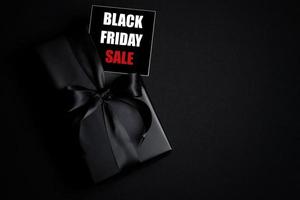 vue de dessus du texte de vente du vendredi noir avec boîte-cadeau noire isolée sur fond noir. photo