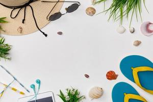 accessoires du voyageur avec coquillages, pantoufles, tablette, lunettes de soleil et chapeau fond blanc isolé, vue aérienne avec espace de copie, concept de voyage tropical photo