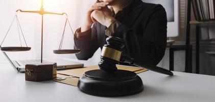 concept de justice et de droit. juge masculin dans une salle d'audience sur une table en bois et conseiller ou avocat masculin travaillant au bureau. concept de droit, de conseil et de justice juridique. photo