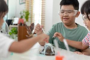 enfants répétant et observant un projet de laboratoire scientifique à la maison - le volcan de bicarbonate de soude et de vinaigre photo