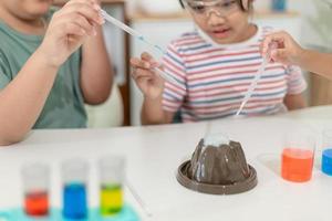 enfants répétant et observant un projet de laboratoire scientifique à la maison - le volcan de bicarbonate de soude et de vinaigre photo