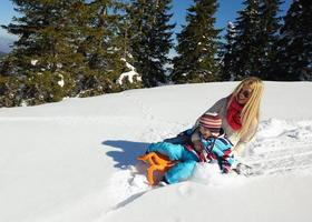 famille s'amusant sur la neige fraîche en hiver photo