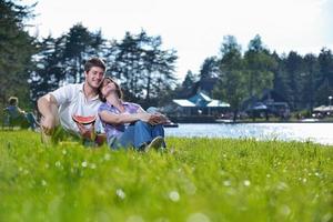 heureux jeune couple ayant un pique-nique en plein air photo