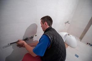 plombier professionnel travaillant dans une salle de bain photo