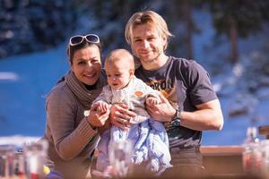 jeune famille heureuse avec petit enfant profitant de la journée d'hiver photo