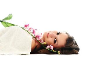 visage de belle jeune femme avec fleur et serviette photo