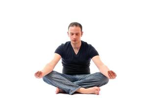 jeune homme en position du lotus faisant du yoga photo