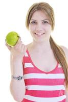 heureuse jeune femme mange une pomme verte isolée sur blanc photo