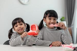 enfant asiatique mignon jouant avec un ensemble de jouets médecin-dentiste, l'enfant montre comment nettoyer et prendre soin des dents. dentisterie et médecine, photo