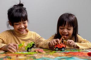 les frères et sœurs des petits enfants jouent avec des jouets sur la table. photo