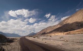 route du désert avec ciel bleu horizon et nuages blancs photo
