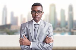 jeune homme d'affaires noir devant la grande ville photo