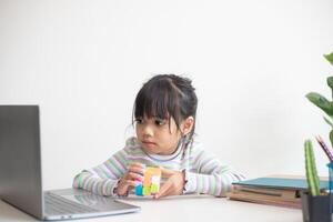 petite fille mignonne asiatique tenant le cube de rubik dans ses mains. rubik's cube est un jeu qui augmente l'intelligence des enfants. photo