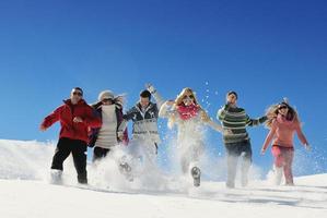 les amis s'amusent en hiver sur la neige fraîche photo