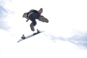 garçon pratiquant le skate dans un skate park - isolé photo